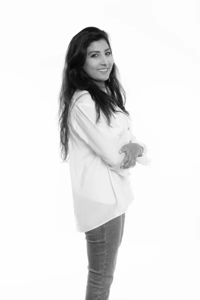 Studio shot of young happy Persian woman smiling and standing with arms crossed — ストック写真