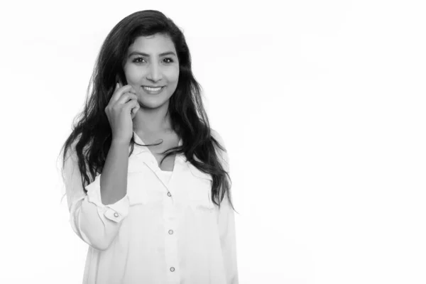 Studio shot of young happy Persian woman smiling while talking on mobile phone — ストック写真