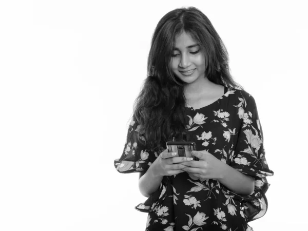 Studioaufnahme einer jungen glücklichen Perserin, die mit dem Handy lächelt — Stockfoto