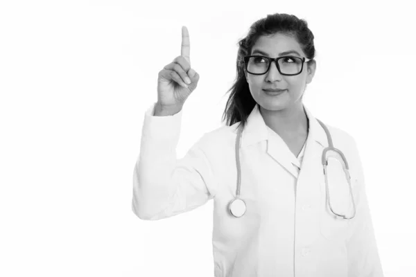 Estúdio tiro de jovem bela mulher persa médico pensando enquanto apontando dedo para cima — Fotografia de Stock