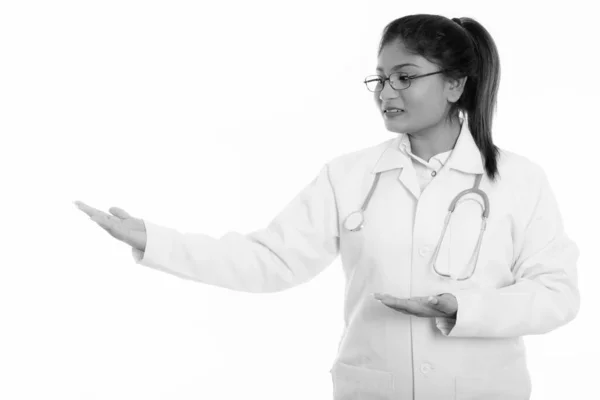 Estudio de tiro de joven feliz mujer persa gorda médico sonriendo mientras muestra algo — Foto de Stock