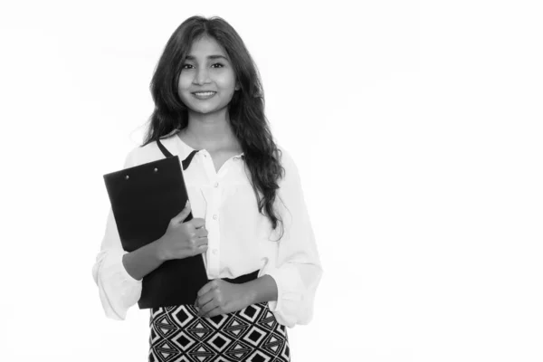Estudio de la joven feliz empresaria persa sonriendo mientras sostiene el portapapeles —  Fotos de Stock