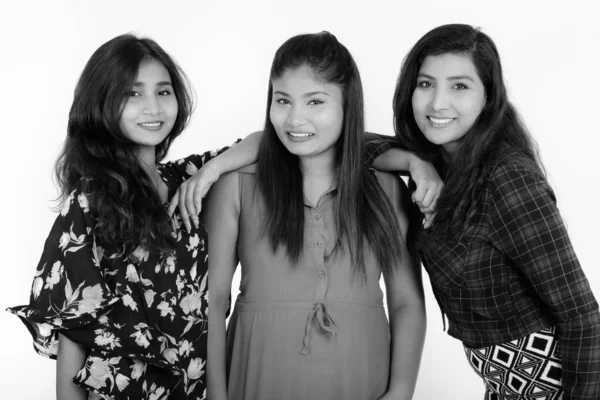 Studio skott av tre glada unga persiska kvinna vänner ler medan lutar sig mot axeln — Stockfoto