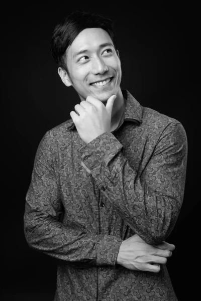 Молодий привабливий азіатський бізнесмен на чорному фоні — стокове фото