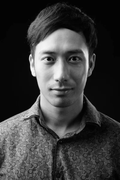 Молодой привлекательный азиатский бизнесмен на черном фоне — стоковое фото