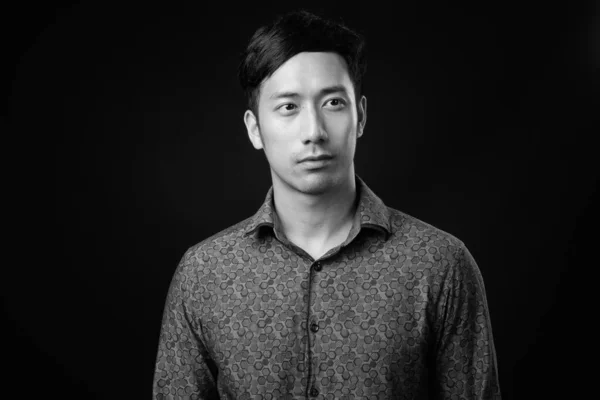 Joven guapo asiático hombre de negocios contra negro fondo —  Fotos de Stock