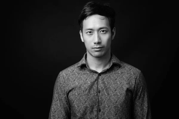 Молодий привабливий азіатський бізнесмен на чорному фоні — стокове фото