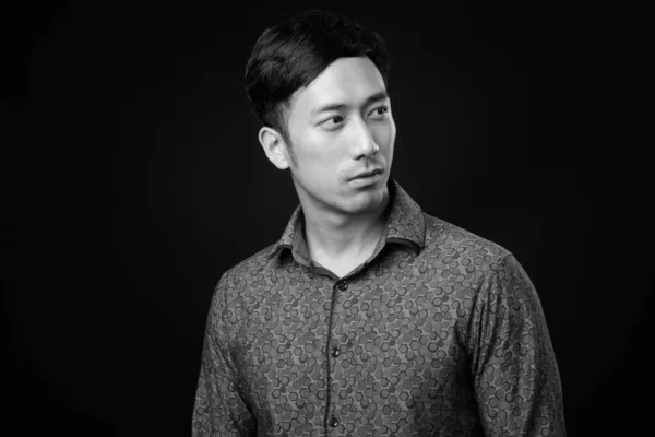 Joven guapo asiático hombre de negocios contra negro fondo —  Fotos de Stock