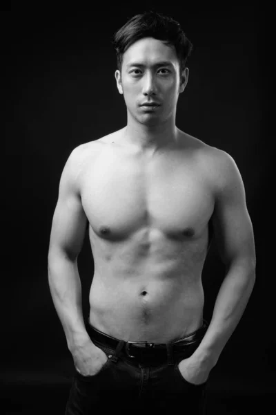 검은 배경에 셔츠를 입지 않고 잘 생긴 젊은 아시아 남자 — 스톡 사진