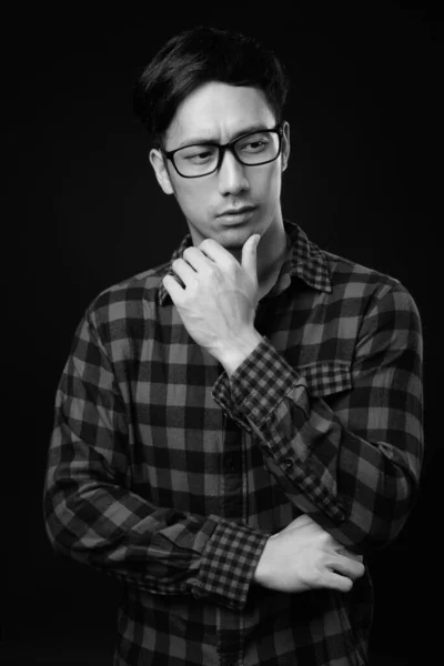 Fiatal csinos ázsiai férfi fekete háttér ellenében — Stock Fotó