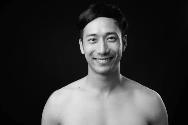 Giovane bello asiatico uomo a torso nudo contro nero sfondo — Foto Stock