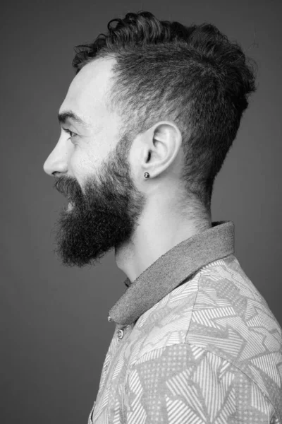 Jovem bonito barbudo persa homem contra cinza fundo — Fotografia de Stock
