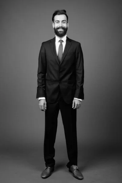 Joven guapo barbudo empresario persa contra fondo gris — Foto de Stock