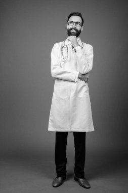 Genç, yakışıklı, sakallı, beyaz arka planda İranlı doktor.