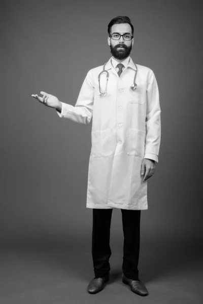 Fiatal jóképű szakállas perzsa férfi orvos ellen szürke háttér — Stock Fotó