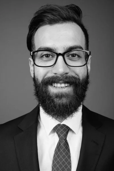 Junger gutaussehender bärtiger persischer Geschäftsmann vor grauem Hintergrund — Stockfoto