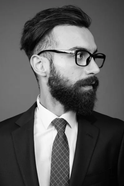 Joven guapo barbudo empresario persa contra fondo gris — Foto de Stock