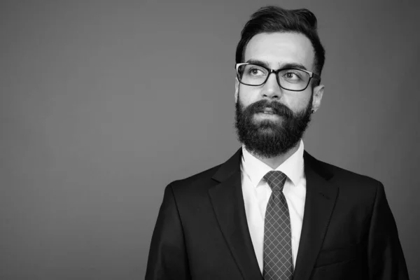 Junger gutaussehender bärtiger persischer Geschäftsmann vor grauem Hintergrund — Stockfoto