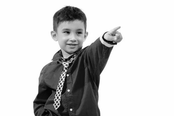 Estúdio tiro de menino feliz bonito sorrindo e apontando o dedo na distância — Fotografia de Stock