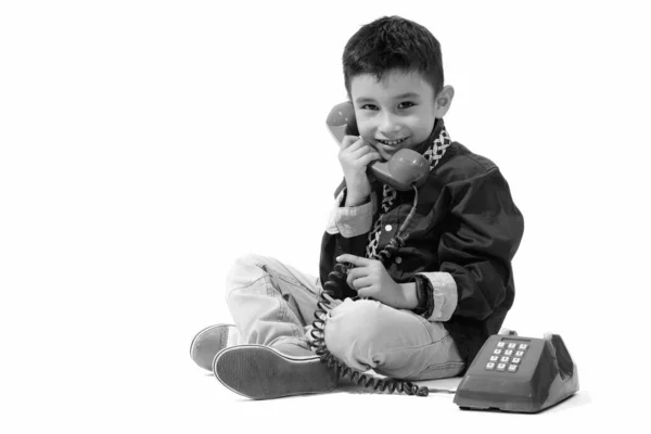 Studio záběr roztomilý šťastný chlapec usmíval a mluvil na starém telefonu — Stock fotografie