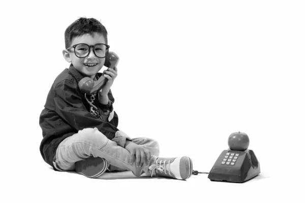 Estúdio tiro de menino feliz bonito sorrindo e falando no telefone antigo — Fotografia de Stock