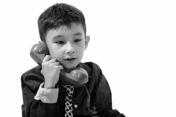 Studio colpo di ragazzo carino parlando sul vecchio telefono e guardando giù — Foto Stock