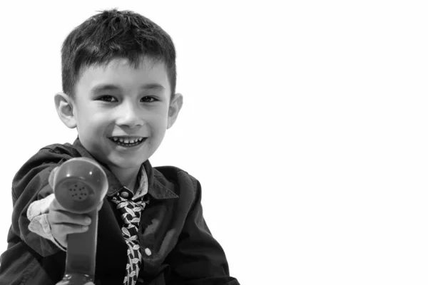 Estúdio tiro de menino feliz bonito sorrindo e dando telefone velho — Fotografia de Stock