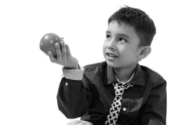 Estúdio tiro de menino feliz bonito sorrindo e dando maçã verde enquanto olha para cima — Fotografia de Stock