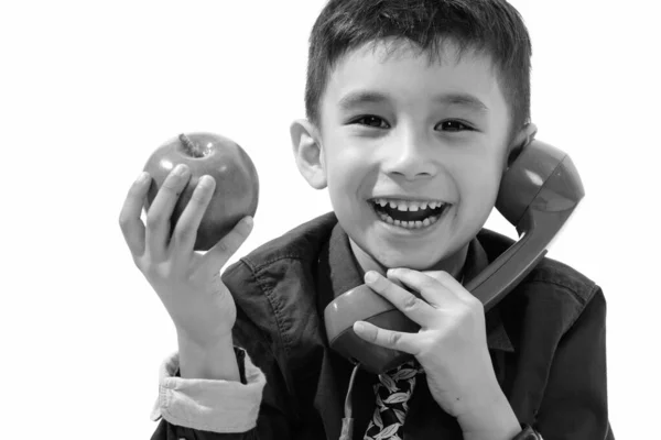 Estúdio tiro de menino feliz bonito sorrindo e segurando maçã verde enquanto fala no telefone antigo — Fotografia de Stock