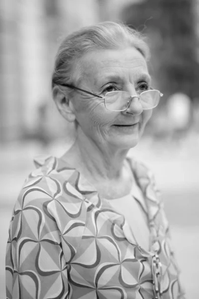 Beautiful senior tourist woman relaxing around the city in black and white — Stock Photo, Image