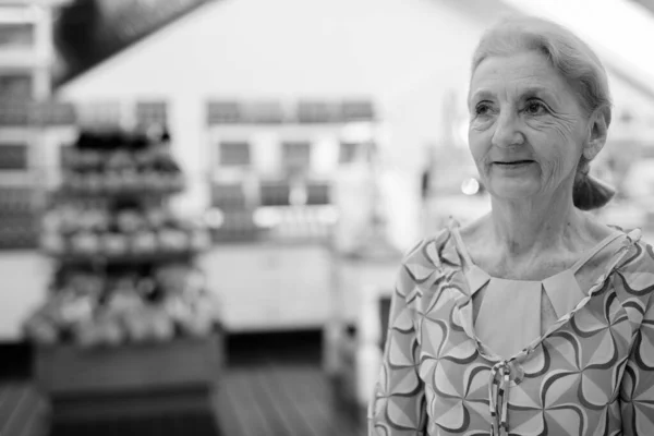 Vacker senior turist kvinna avkopplande runt staden i svart och vitt — Stockfoto