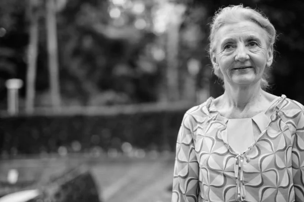 Vacker senior turist kvinna avkopplande runt staden i svart och vitt — Stockfoto