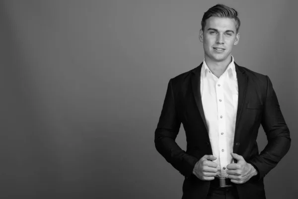 Retrato de un joven hombre de negocios guapo con traje en blanco y negro — Foto de Stock