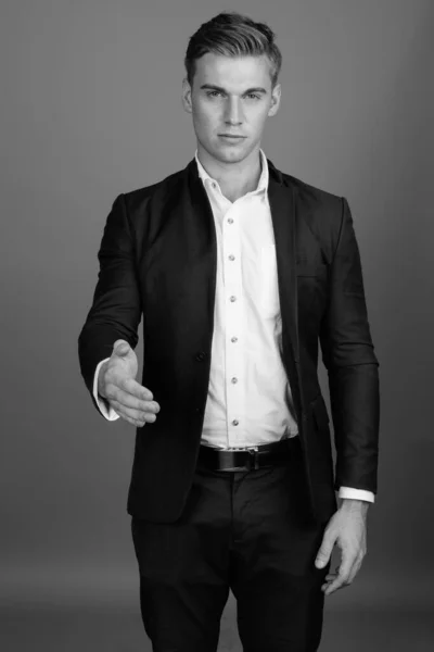 Portrét mladého pohledného podnikatele v černém a bílém obleku — Stock fotografie