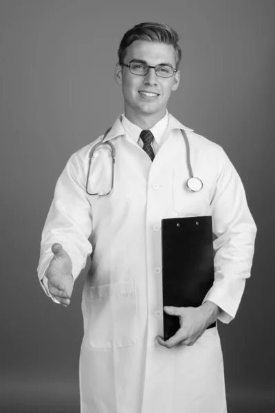 Portrét mladého pohledného muže lékaře s brýlemi v černé a bílé — Stock fotografie