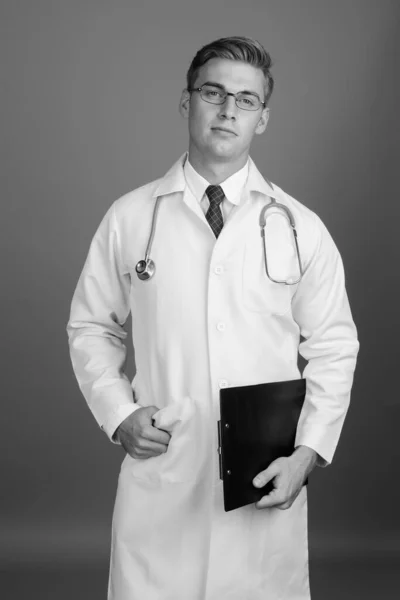 Portrét mladého pohledného muže lékaře s brýlemi v černé a bílé — Stock fotografie