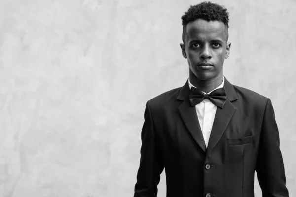 Jonge knappe Afrikaanse zakenman draagt pak tegen betonnen muur buiten — Stockfoto