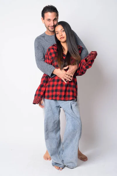 Ganzkörperaufnahme eines multiethnischen Paares, das sich umarmt — Stockfoto