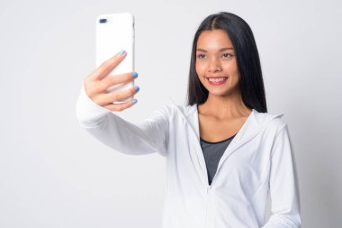 Mutlu Asyalı bir kadının portresi. Beden eğitimi için selfie çekiyor.