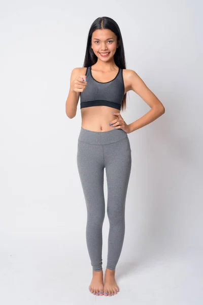 Helkroppsbild av glad ung asiatisk kvinna pekar på kameran redo för gym — Stockfoto