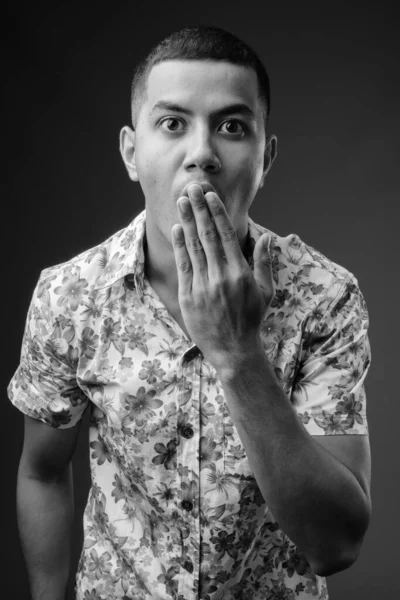 Young multi-ethnic Asian tourist man against brown background — Stock Photo, Image