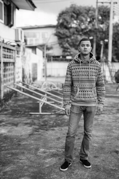 Молодий чоловік з багатонаціональності на вулиці в чорно - білому — стокове фото
