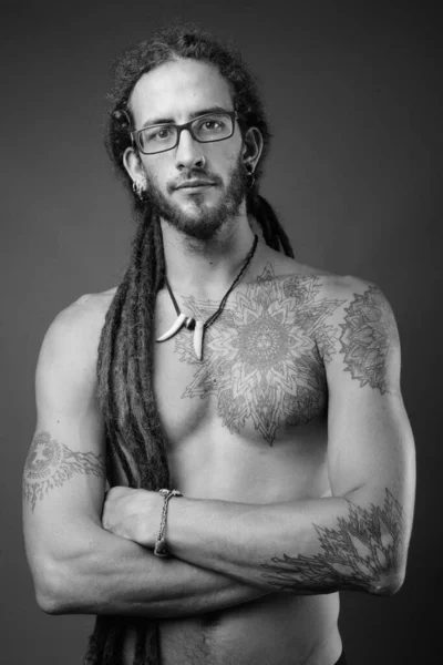Junger hübscher hispanischer Mann mit Dreadlocks ohne Hemd in schwarz und weiß — Stockfoto