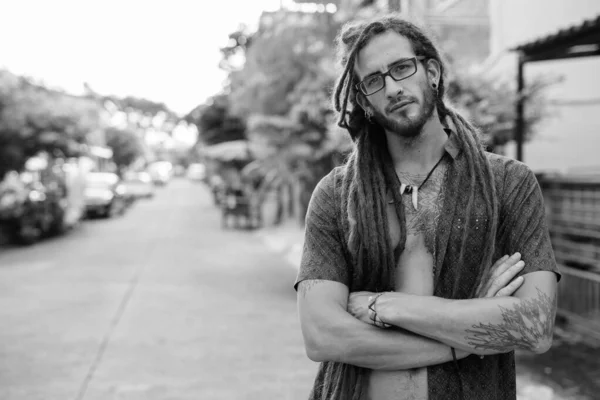 Jovem bonito turista hispânico homem com dreadlocks ao ar livre em preto e branco — Fotografia de Stock