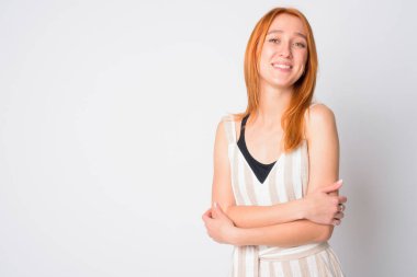 Kollarını kavuşturup gülümseyen mutlu, genç, güzel bir kadının portresi.