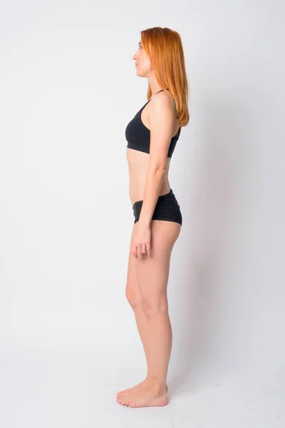 Full body shot profile view of young beautiful redhead woman in lingerie — ストック写真