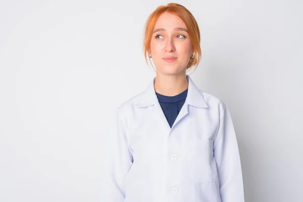 Porträtt av ung vacker rödhårig kvinna läkare tänker — Stockfoto