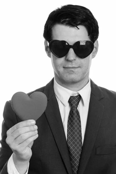 Schöner Geschäftsmann mit herzförmiger Sonnenbrille und rotem Herz — Stockfoto