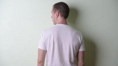 Sarı saçlı genç adam etrafa bakıyor.