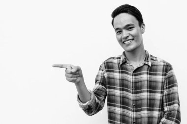 Beyaz duvara karşı siyah beyaz giysili yakışıklı bir Hintli.